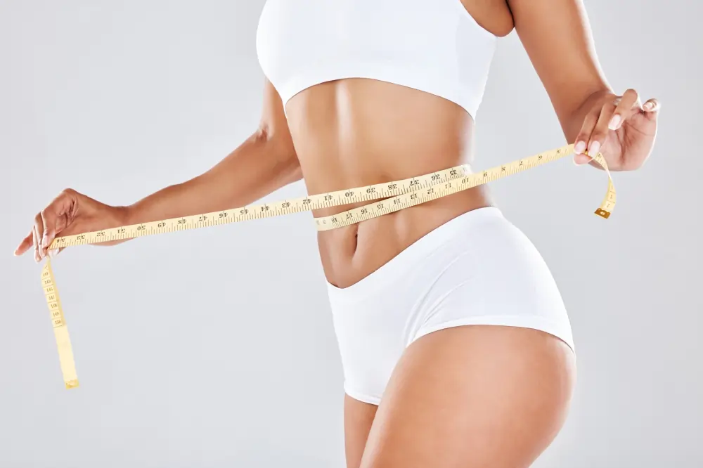 a woman measuring her waist with weight-managementin Northborough, MA